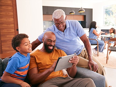 son, father, and grandfather looking at photos on a tablet