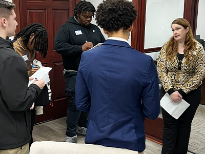 employee sharing information with students on how banks serve the community