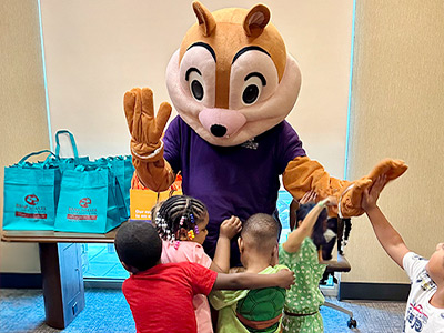Savemore the Squirrel giving high-fives to pre-K students