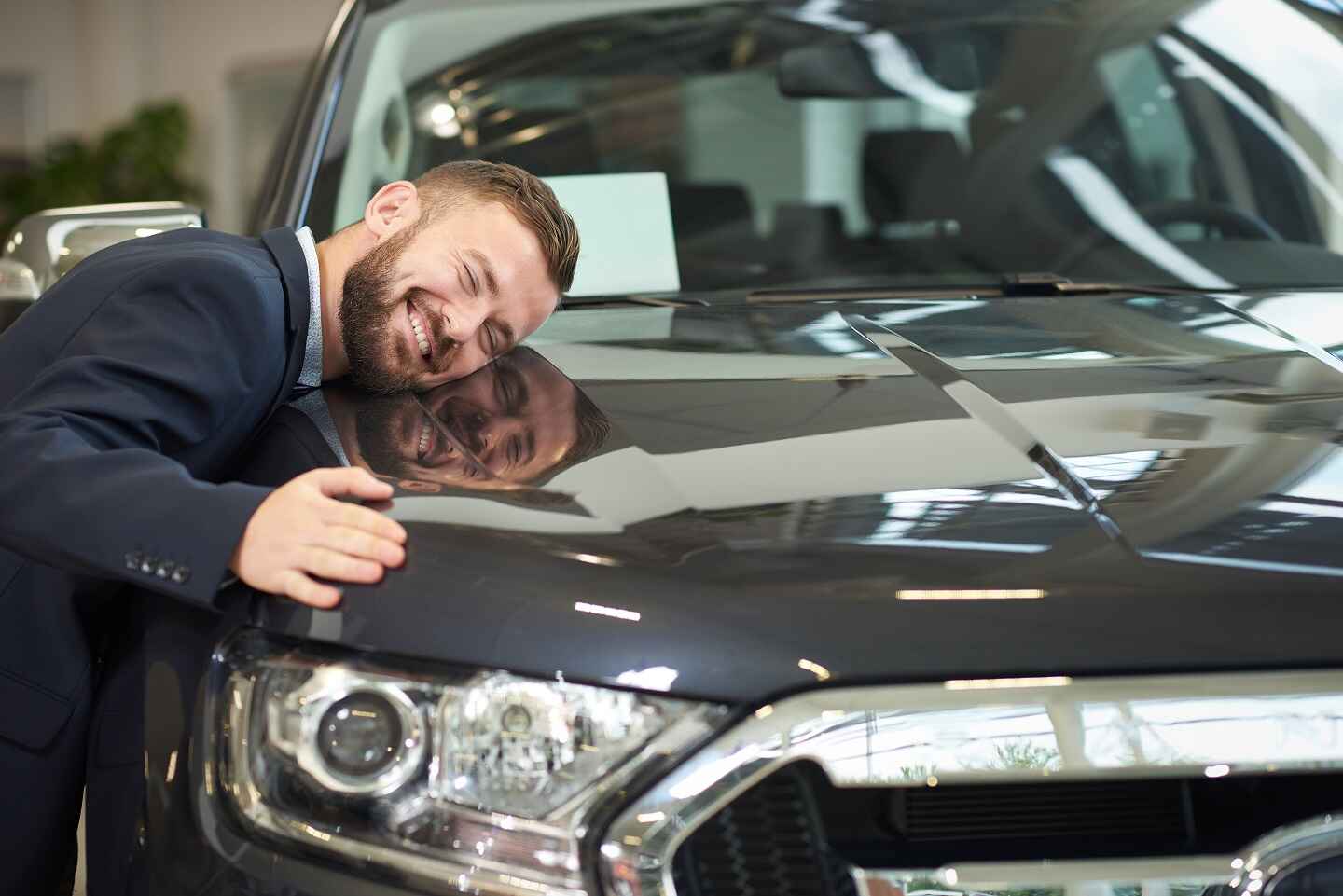 Man hugging a new car