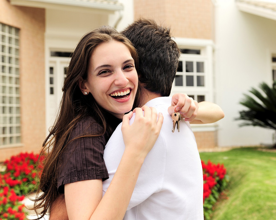 Couple hugging after buying home