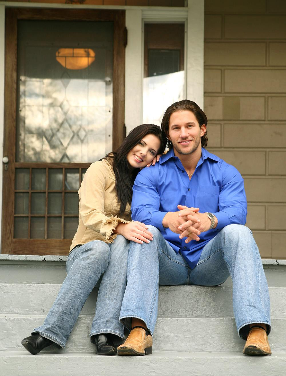 Couple sitting in front of new home