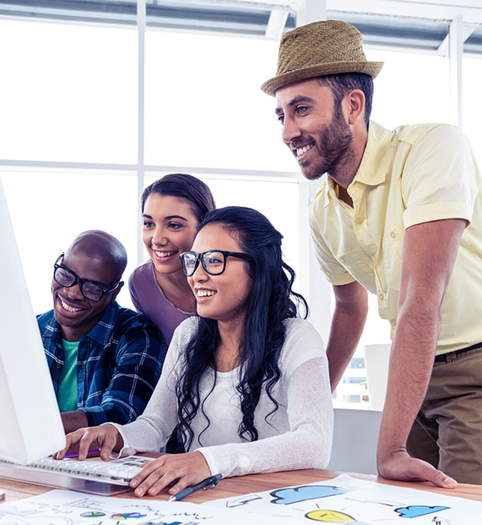 work team gathered around a computer monitor