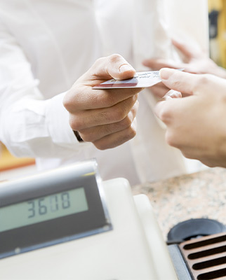 customer handing their debit card to a cashier at a store