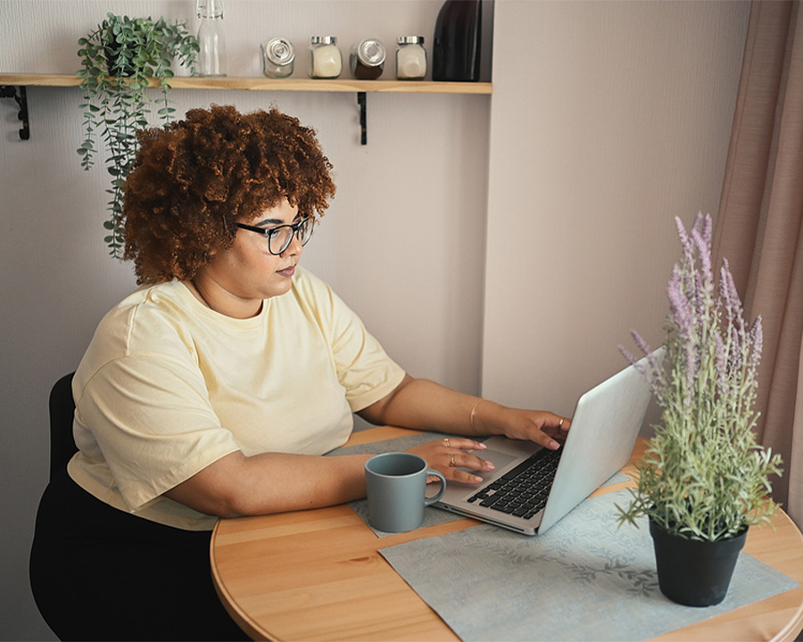 woman using her laptop while drinking tea