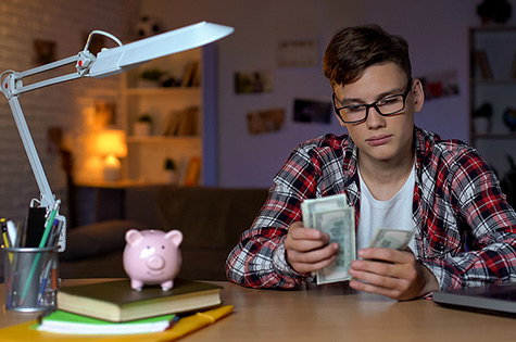 boy counting cash at desk