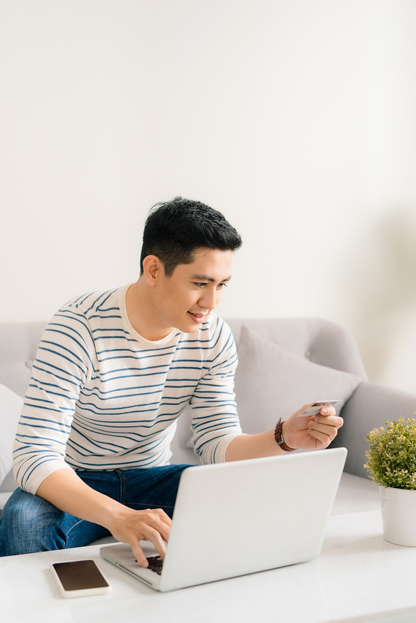 man using credit card and laptop